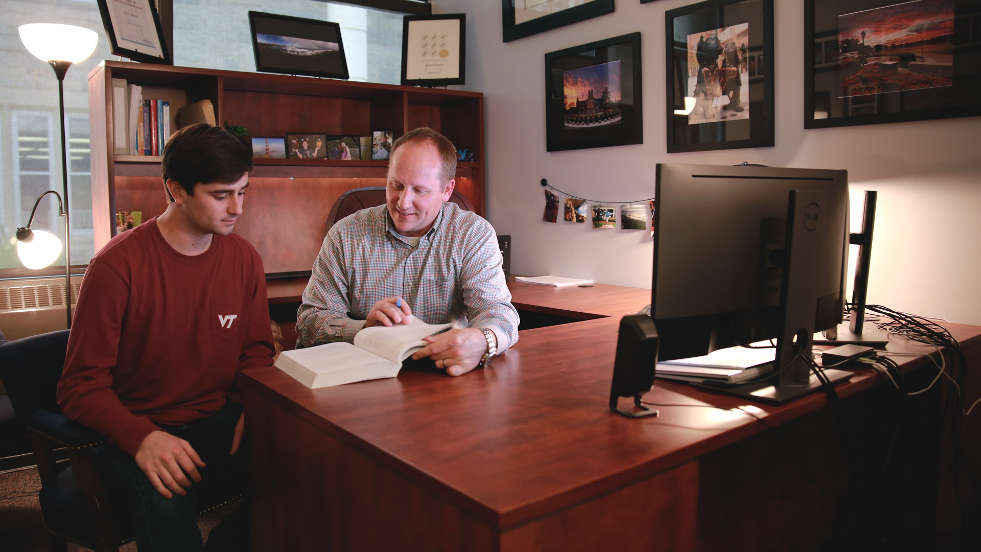 Jason Deane reviews some assignments with his graduate student Brian Hill.